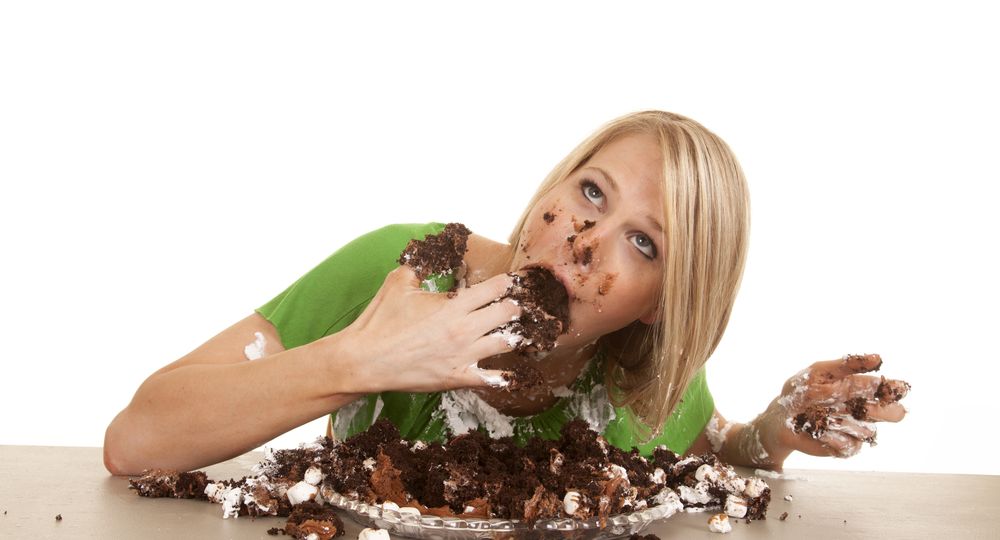 A,Woman,Shoving,Her,Face,With,Cake,.